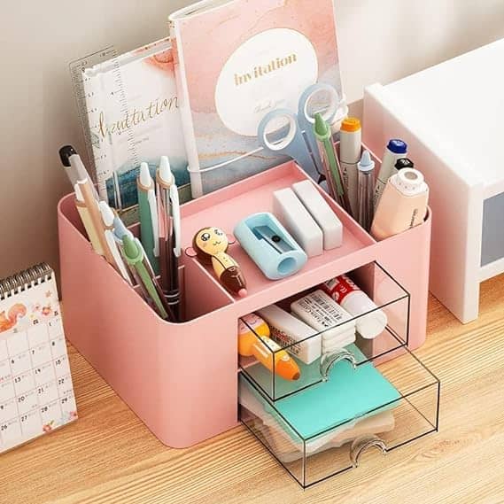 a pink desk organizer with stationery on a desk