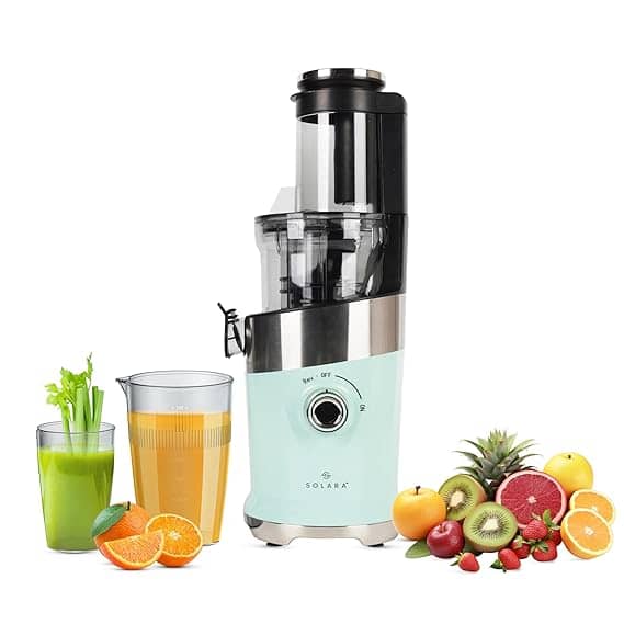 a juicer with fruits and a glass of juice